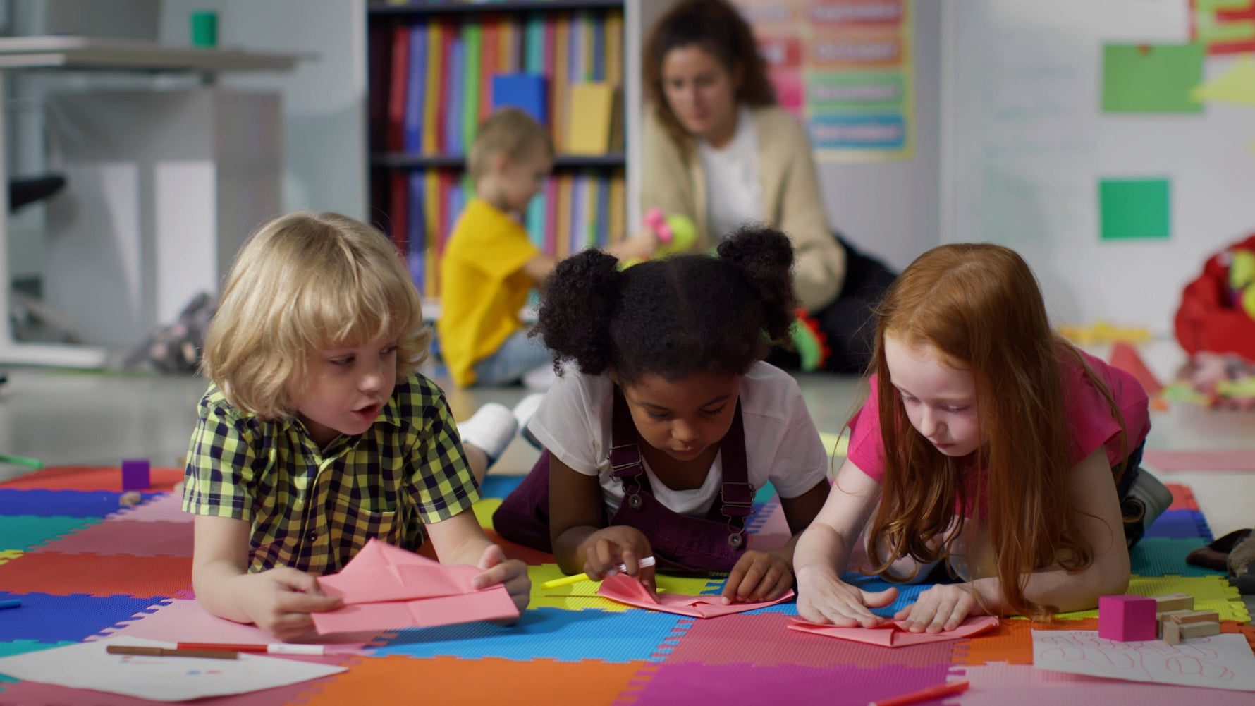 Preschool children learning to fold origami paper