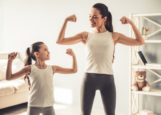 Two women flexing their arms together in a confident power pose