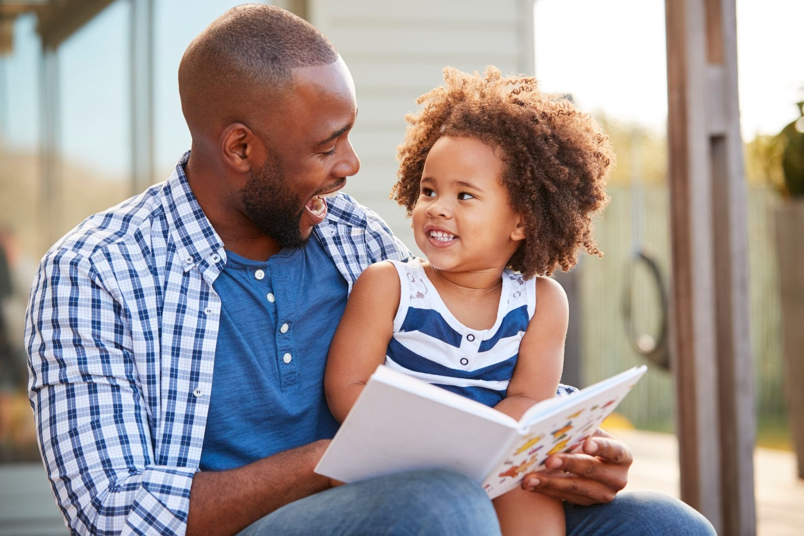 Trauma Informed Coaching sample; A father black dad laughing with child and having emotional connection