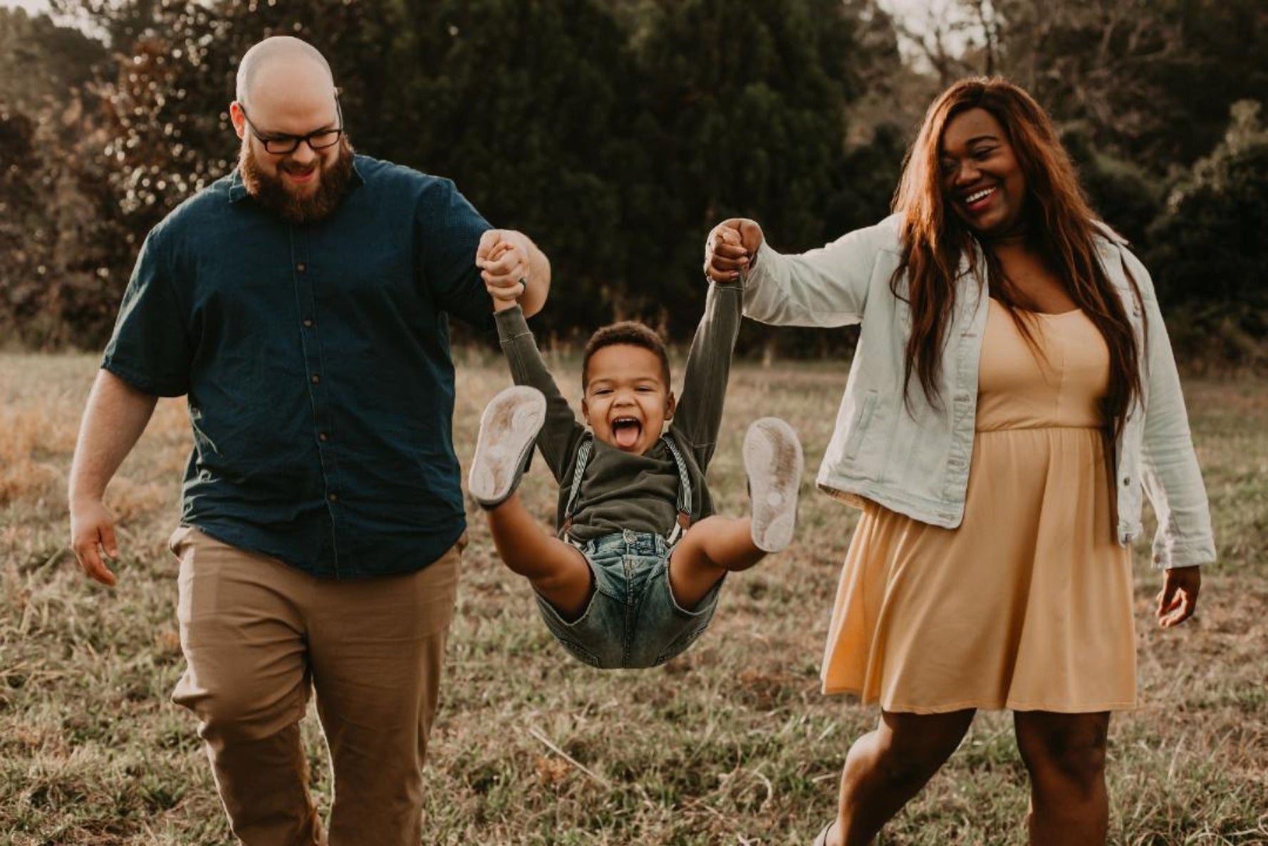 Mom and dad swinging their son