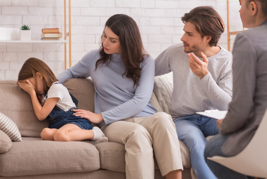 mother and father comforting a child in the office of her therapist