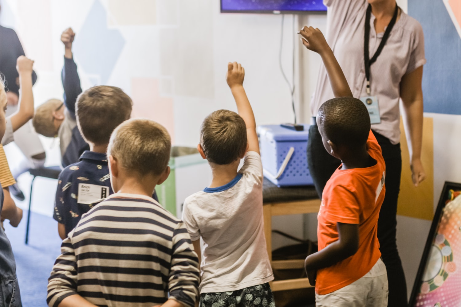 children in school raising their hands