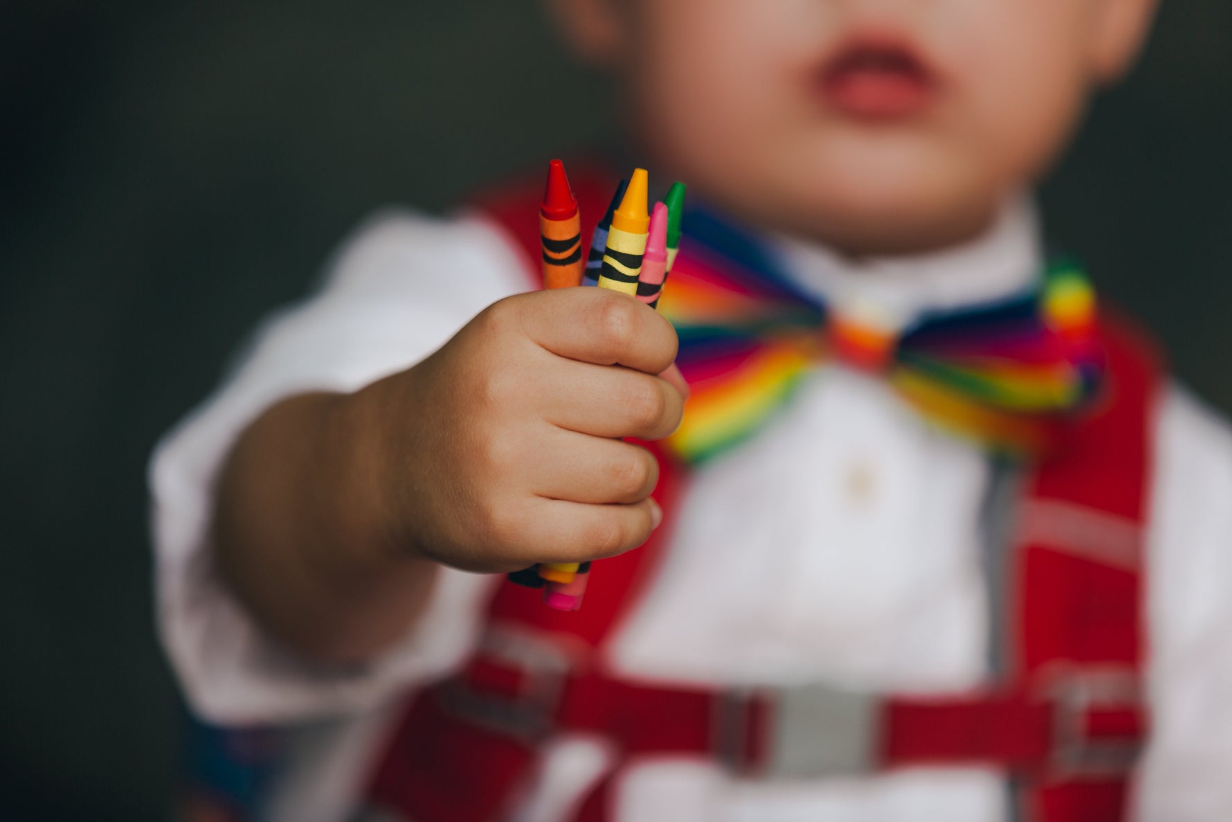 Child holding colorful crayons