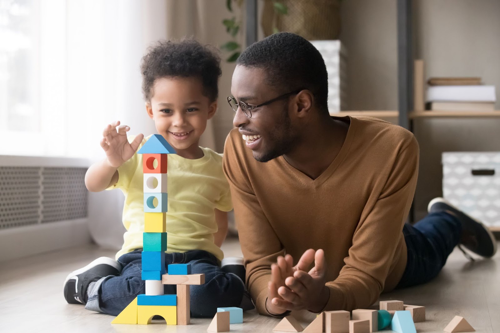 Happy father and his son building with blocks.