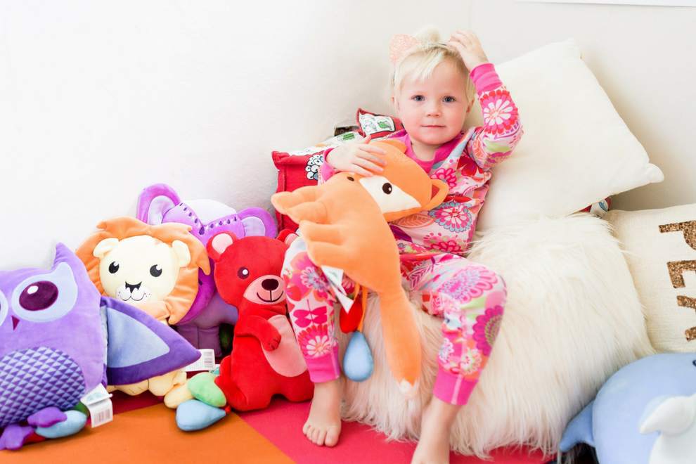 toddler holding orange fox emotions plush stuffed animal in a calming corner