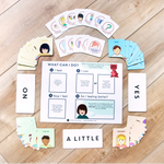 A children's emotional regulation game board and cards featuring 32 feelings from four mood groups: HAPPY, SAD, CALM, and MAD/SCARED, arranged in a circle on a light wood floor along with three response cards reading YES, NO, and A LITTLE, and 12 unique calming strategies cards, all part of Generation Mindful's Time-In Toolkit.